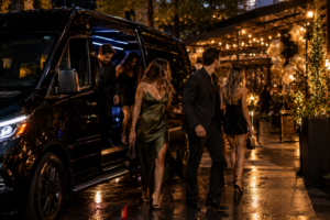 Group of friends dressed up stepping out of a black Sprinter van for a birthday celebration in Detroit